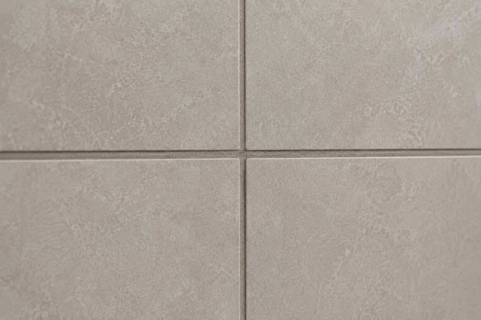 Close-up of perfectly aligned light grey tiles with clean grout lines